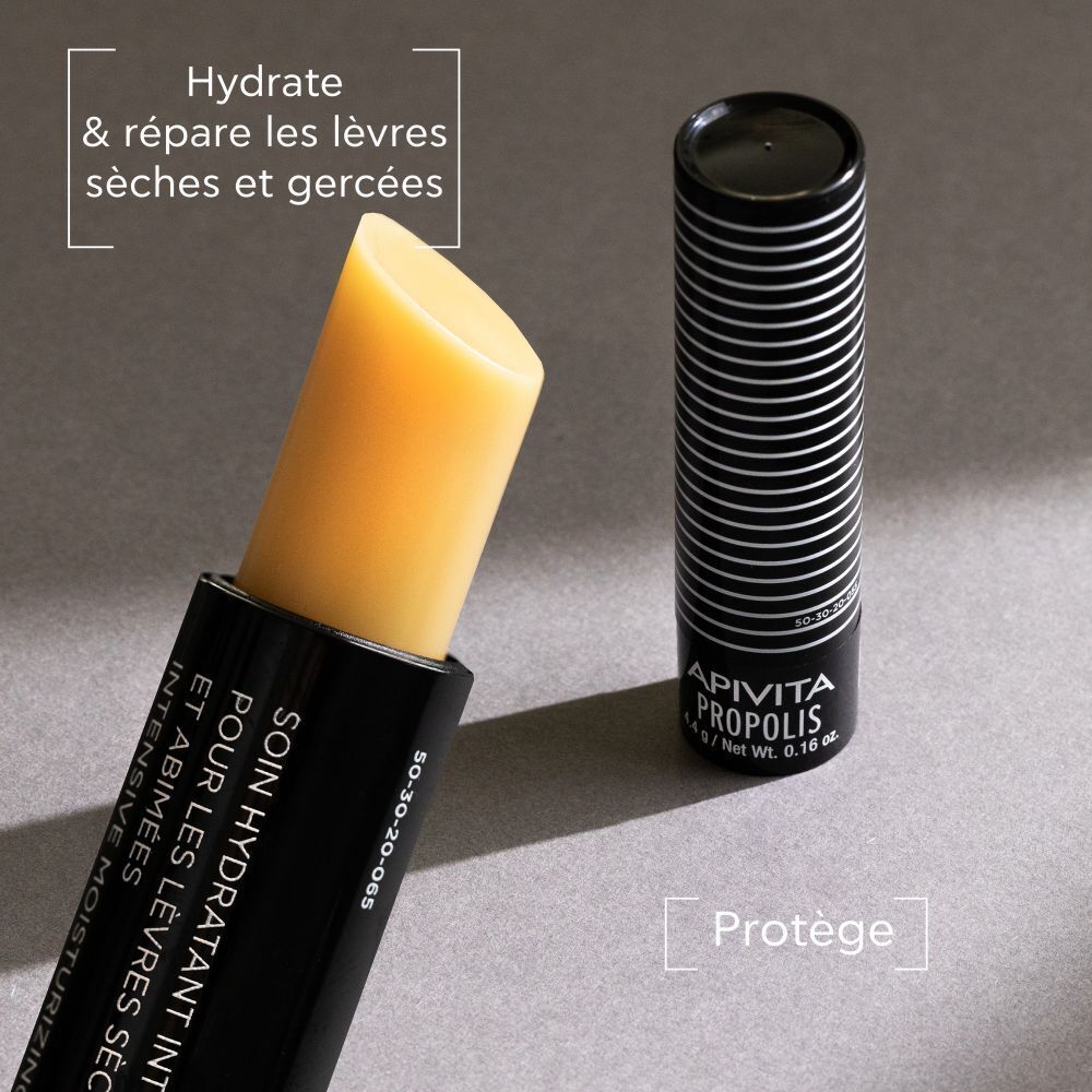 Stick à lèvres Apivita Propolis, tube ouvert, stick visible. Texte : 'Hydrate & répare les lèvres sèches et gercées'.