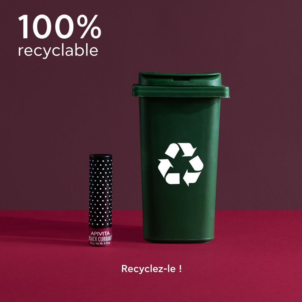 Stick de soin pour les lèvres à côté d'une poubelle de recyclage. 100% recyclable.