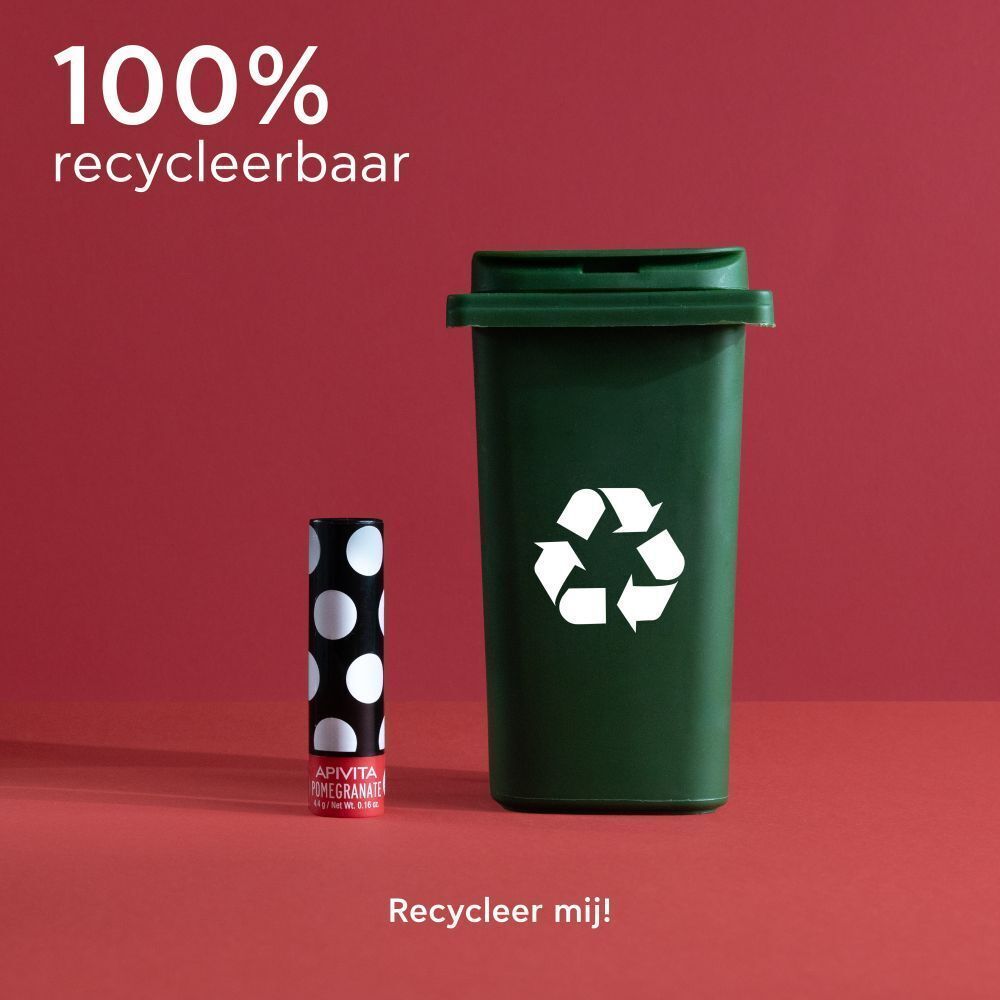 Lippenbalsemstift naast een groene afvalbak voor recycling.