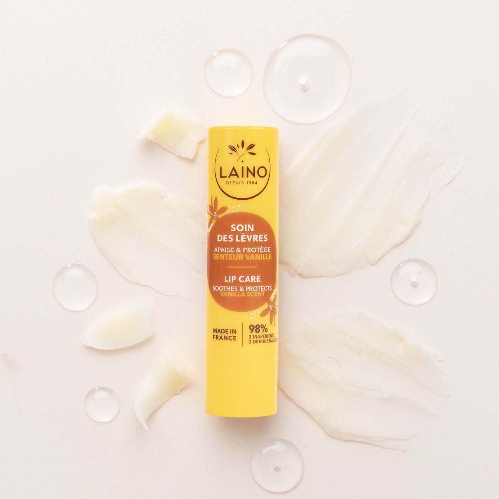 Gele Laino lippenbalsem tube, omringd door romige texturen en waterdruppels.