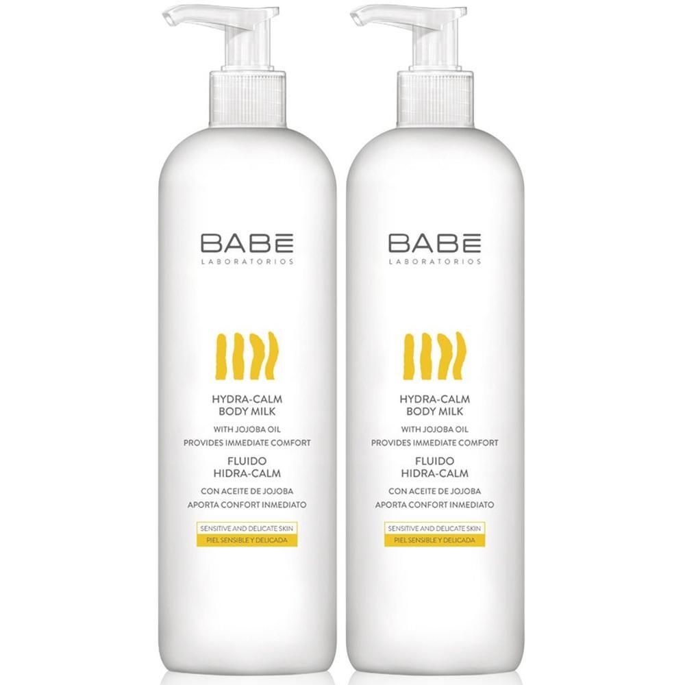 Twee witte BABÉ Hydra-Calm Body Milk pompflesjes met jojobaolie voor de gevoelige huid.