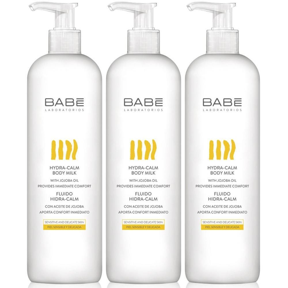 Drie witte BABÉ Hydra-Calm Body Milk pompflesjes met jojobaolie voor de gevoelige huid.
