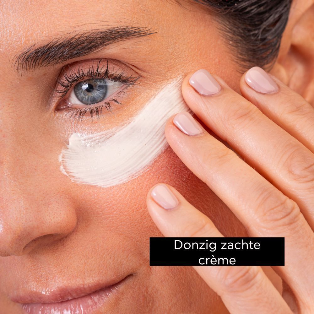 Vrouw brengt Apivita oogmasker aan. Zachte, romige textuur voor de oogzone.