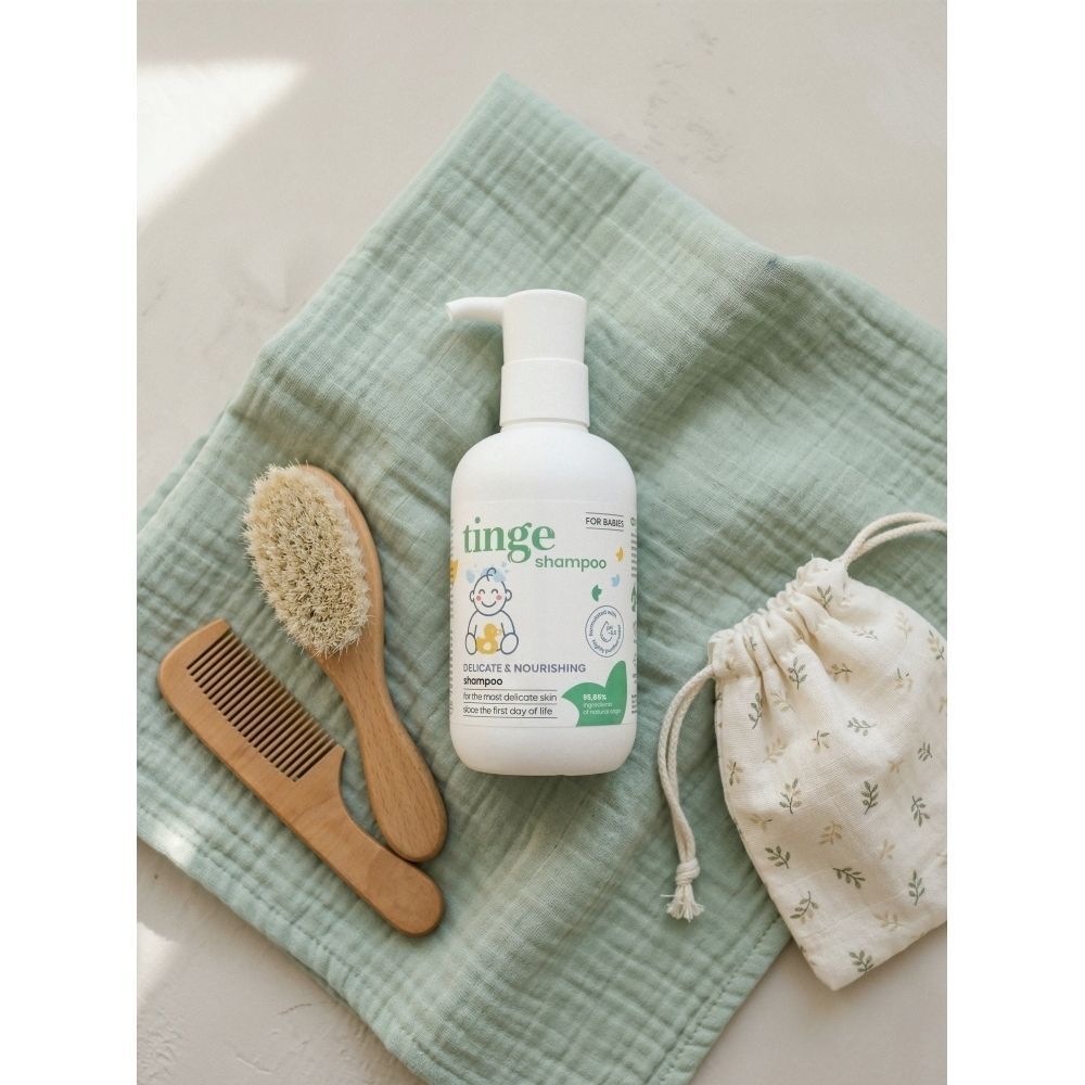 Fles Tinge babyshampoo met diverse toepassingssymbolen.