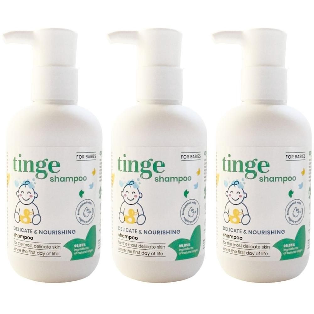 Drie witte flessen Tinge babyshampoo met pompdoseerders, op witte achtergrond.