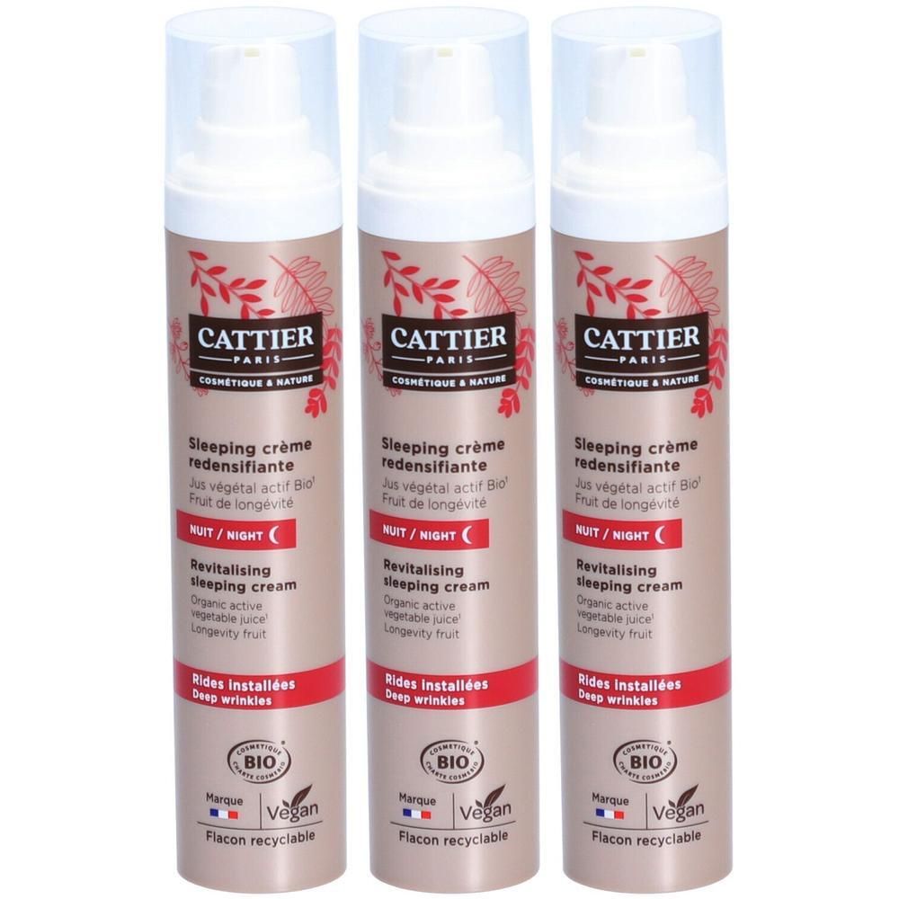 Drie flacons Cattier Redensifiante Nachtcrème met pompdispenser. Beige en rode verpakking met plantenmotief.