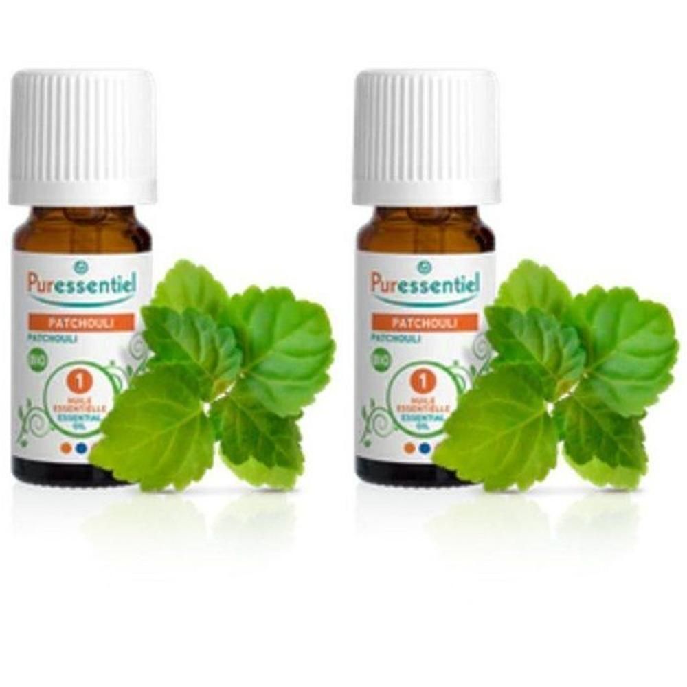 Twee flesjes Puressentiel Patchouli Biologische Essentiële Olie met groene bladeren.