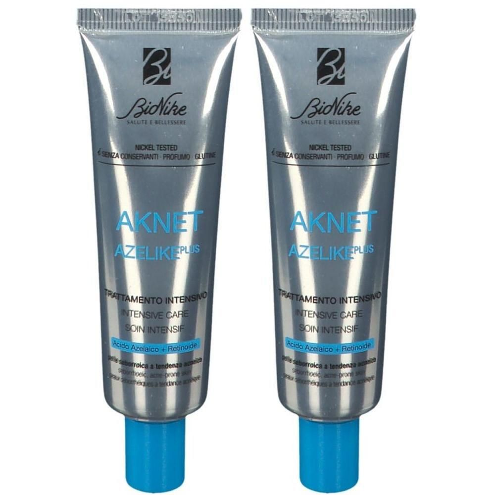 Twee zilverkleurige tubes BioNike Aknet Azelike Plus Intensieve Verzorging met blauwe doppen.
