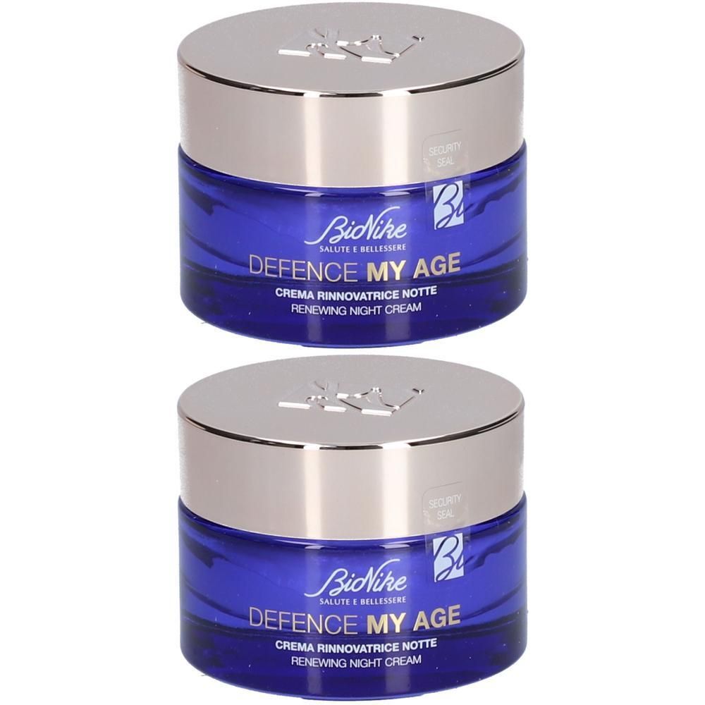Deux pots de crème de nuit BioNike Defence My Age avec couvercles argentés et corps en verre bleu.