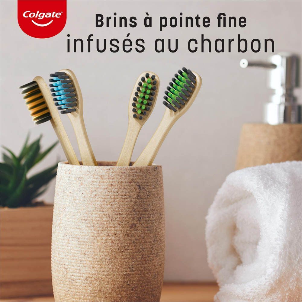 Quatre brosses à dents en bambou à poils fins dans un pot, certaines infusées au charbon.