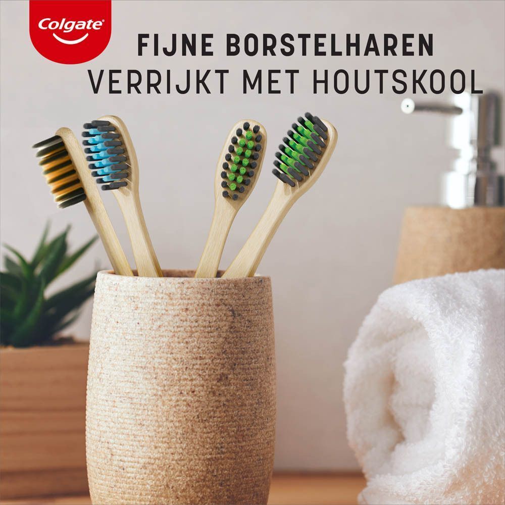 Vier bamboe tandenborstels met fijne borstelharen in een houder, sommige met houtskool.