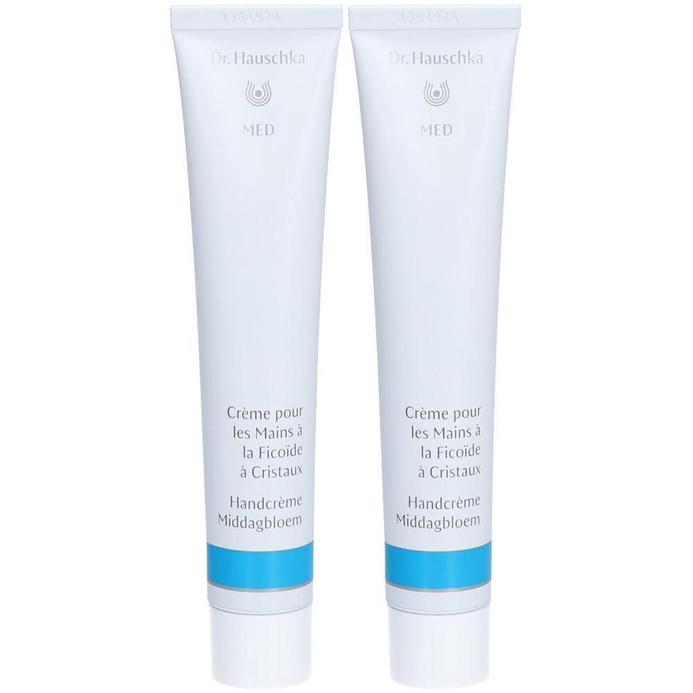 Deux tubes blancs de crème pour les mains Dr. Hauschka Med avec une bande bleue.