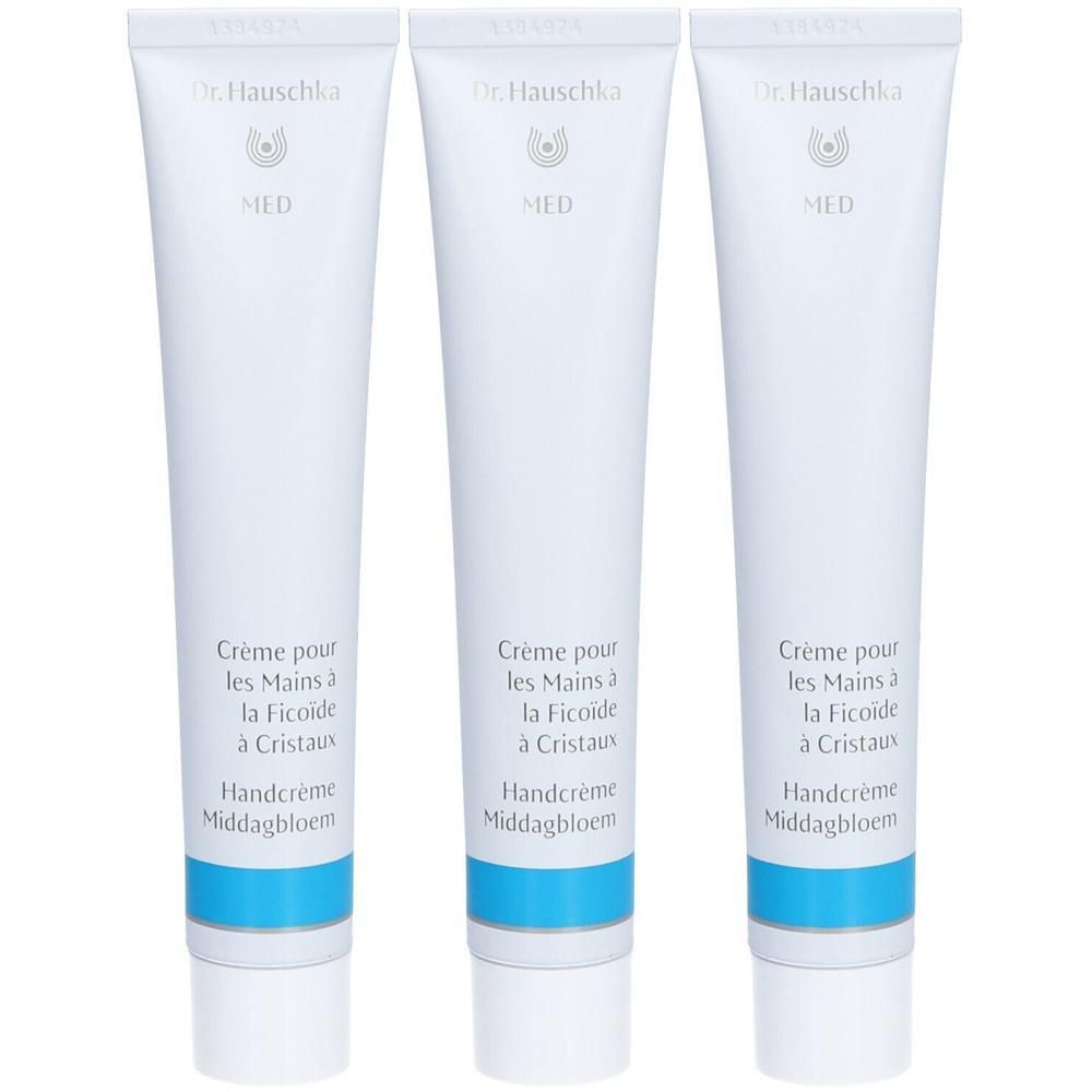 Trois tubes blancs de crème pour les mains avec bande bleue. Dr. Hauschka MED.
