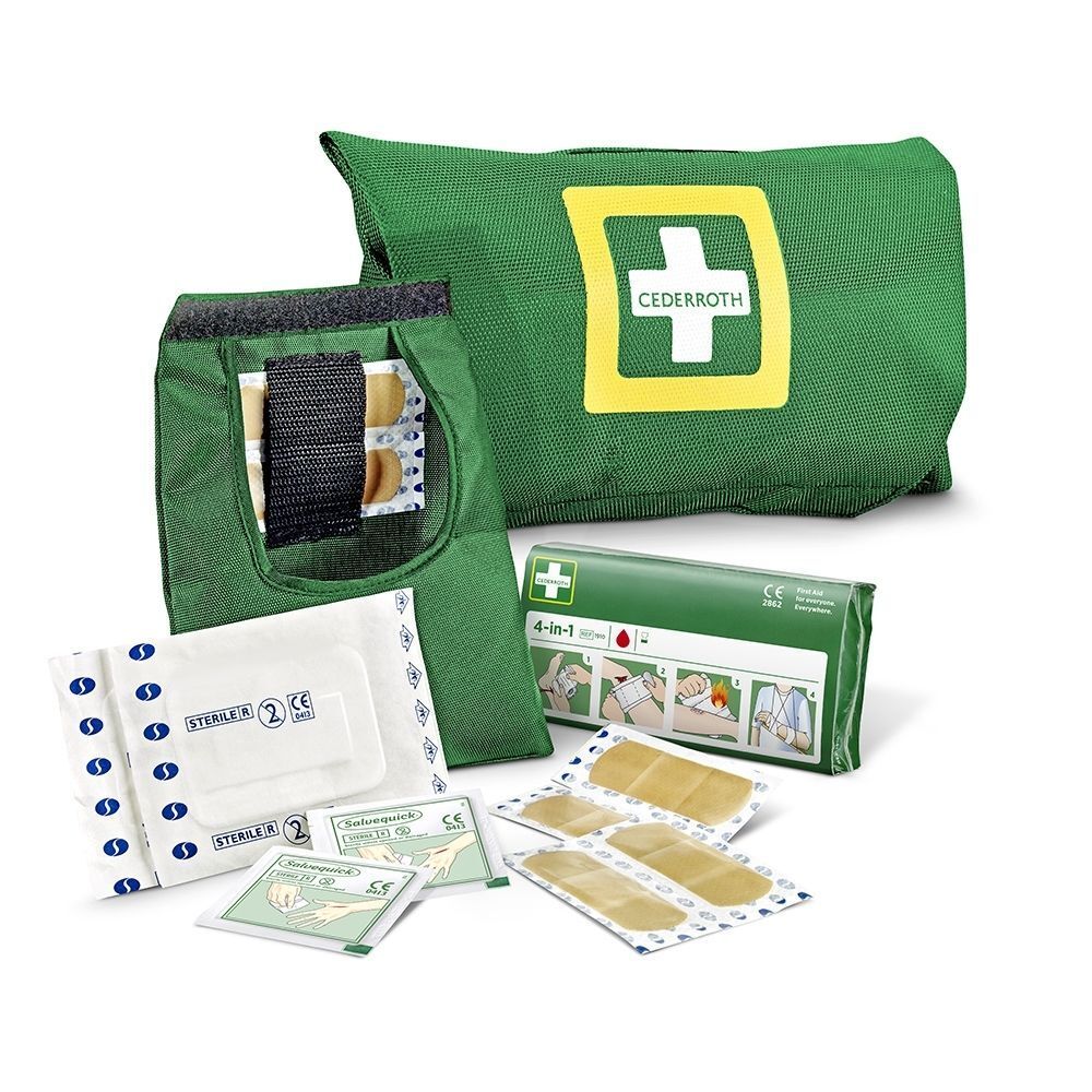 Pochette de premiers secours verte ouverte avec pansements, matériel de bandage et instructions.