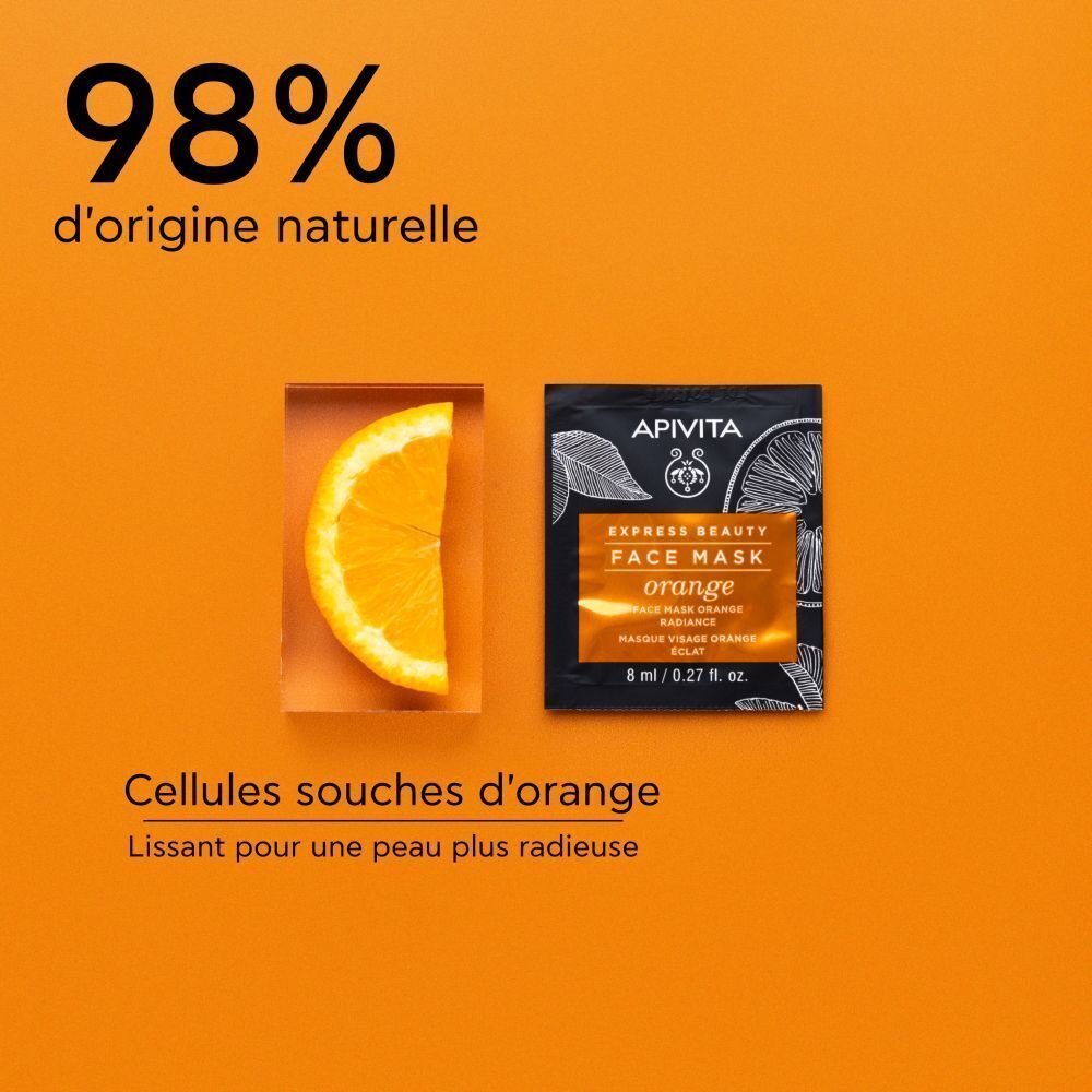 Un paquet de masque visage Apivita Express Beauty Orange à côté d'une tranche d'orange.