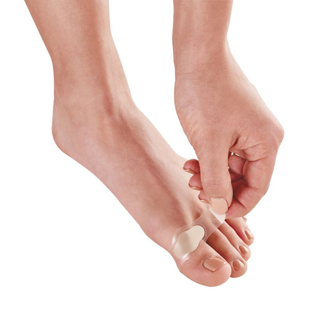 Femme appliquant un pansement ampoule Nexcare entre les orteils.