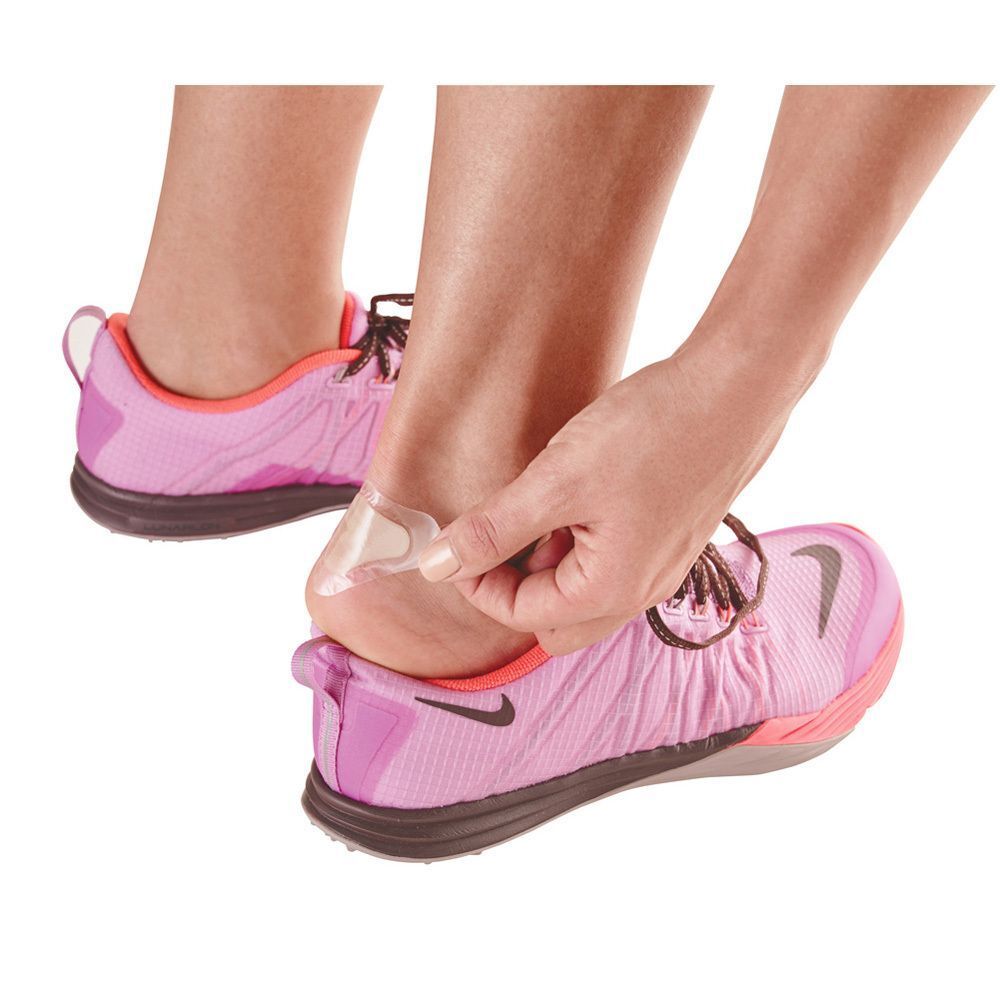 Une personne applique un pansement ampoule Nexcare Soin des pieds sur son talon pour prévenir les frottements dans une chaussure de sport.