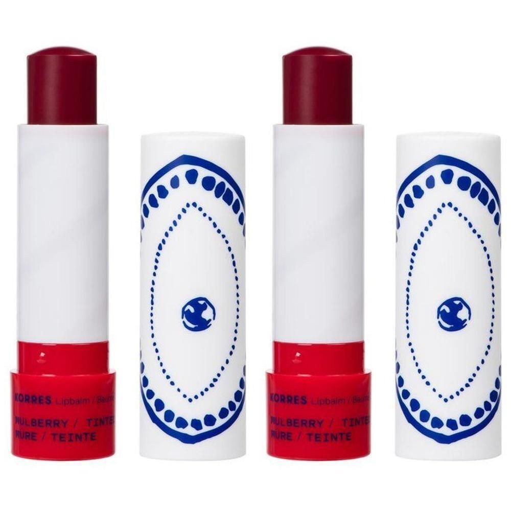 Twee Korres lippenbalsems, wit met blauwe versieringen en rode basis.