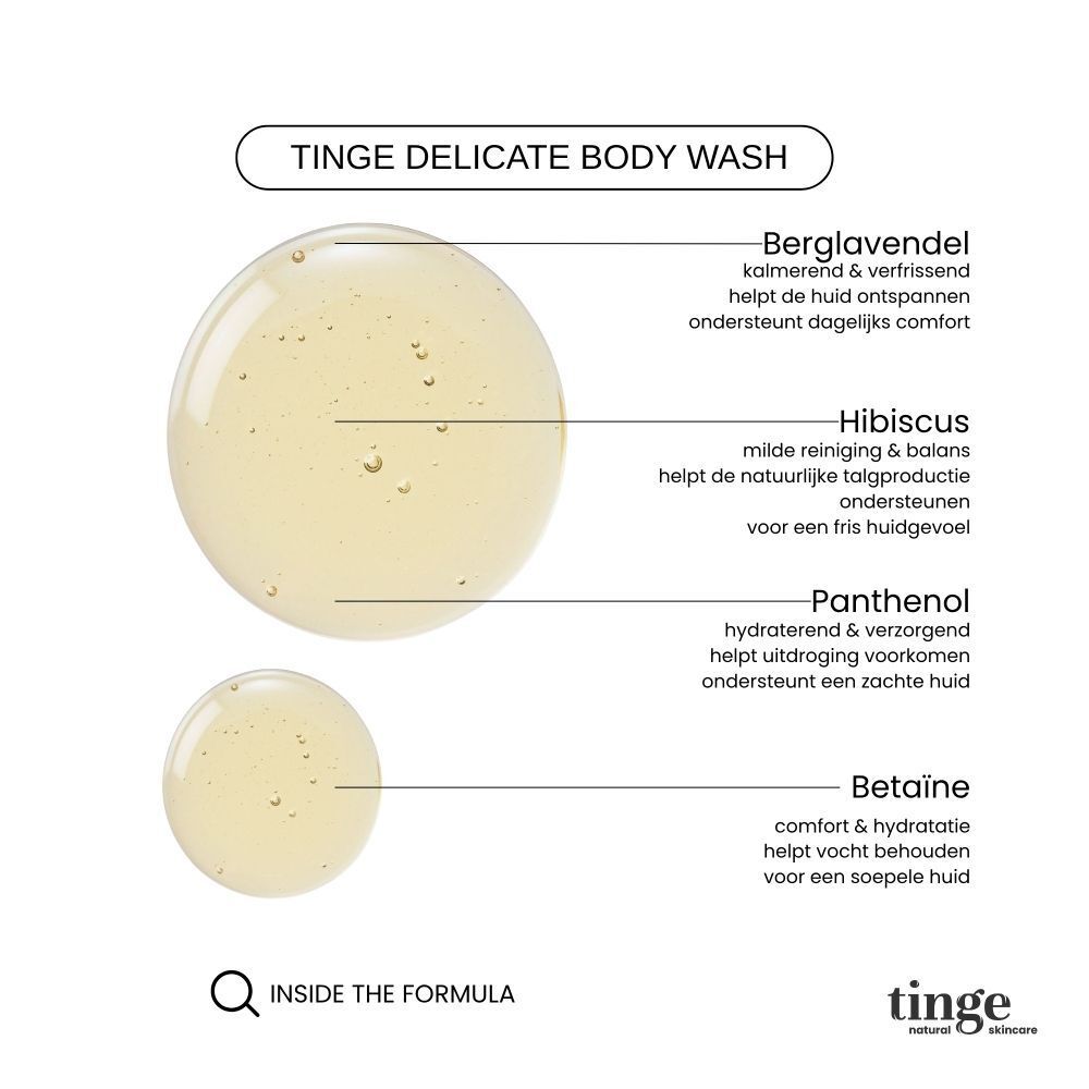 Fles Tinge Bodywash met houten dop, naast een opgevouwen handdoek en lavendel.