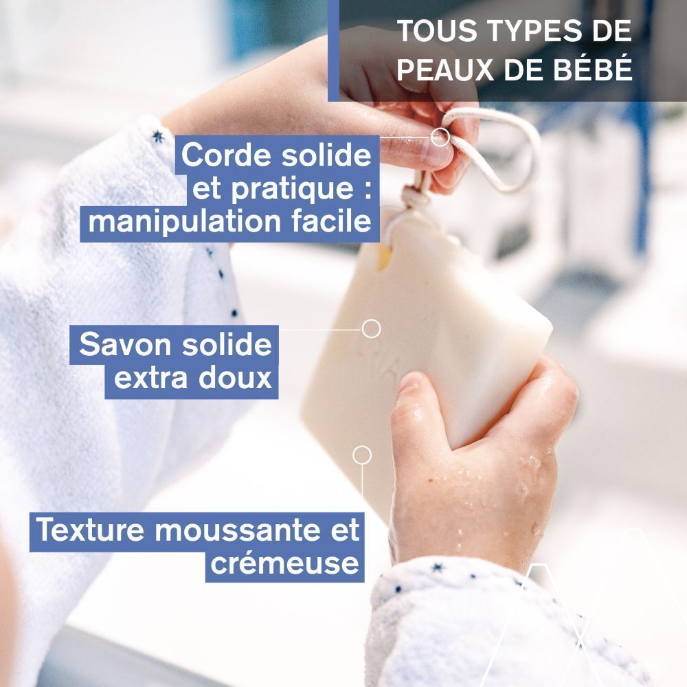 Mains tenant un pain lavant solide avec cordon. Mousse.