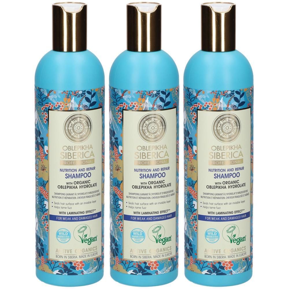 Trois bouteilles de shampoing Oblepikha Siberica avec un motif floral et des bouchons dorés.