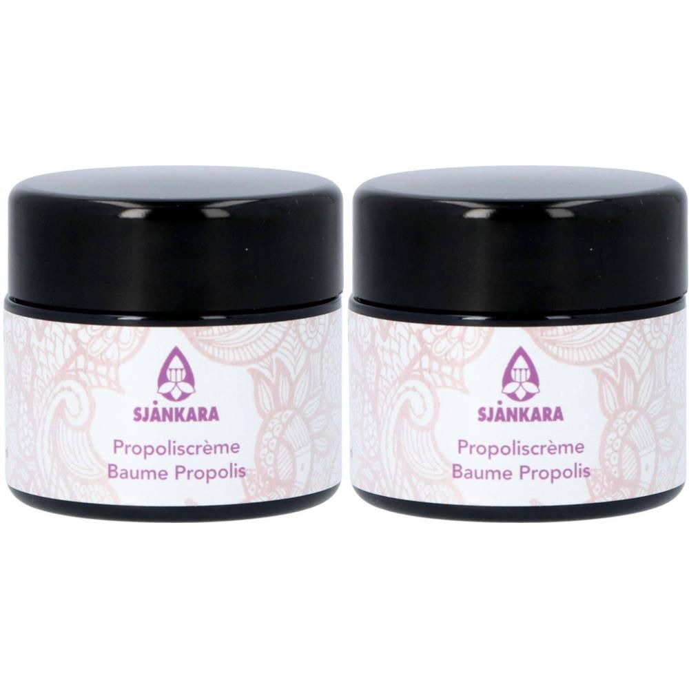 Deux pots de Baume Propolis Sjankara avec couvercles noirs et motif floral.