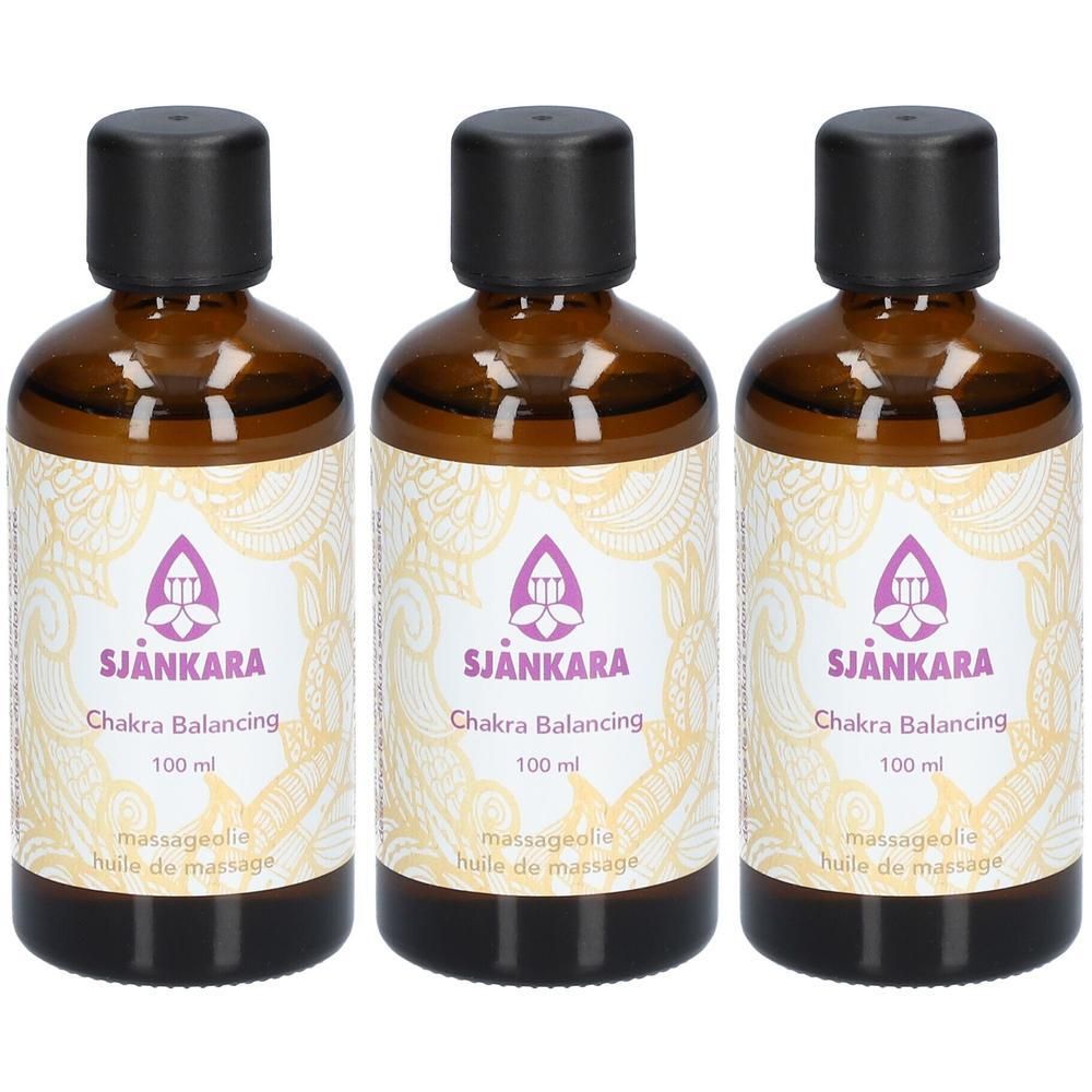 Drie bruine glazen flesjes met zwarte dop, gevuld met Chakra Balancing massageolie.