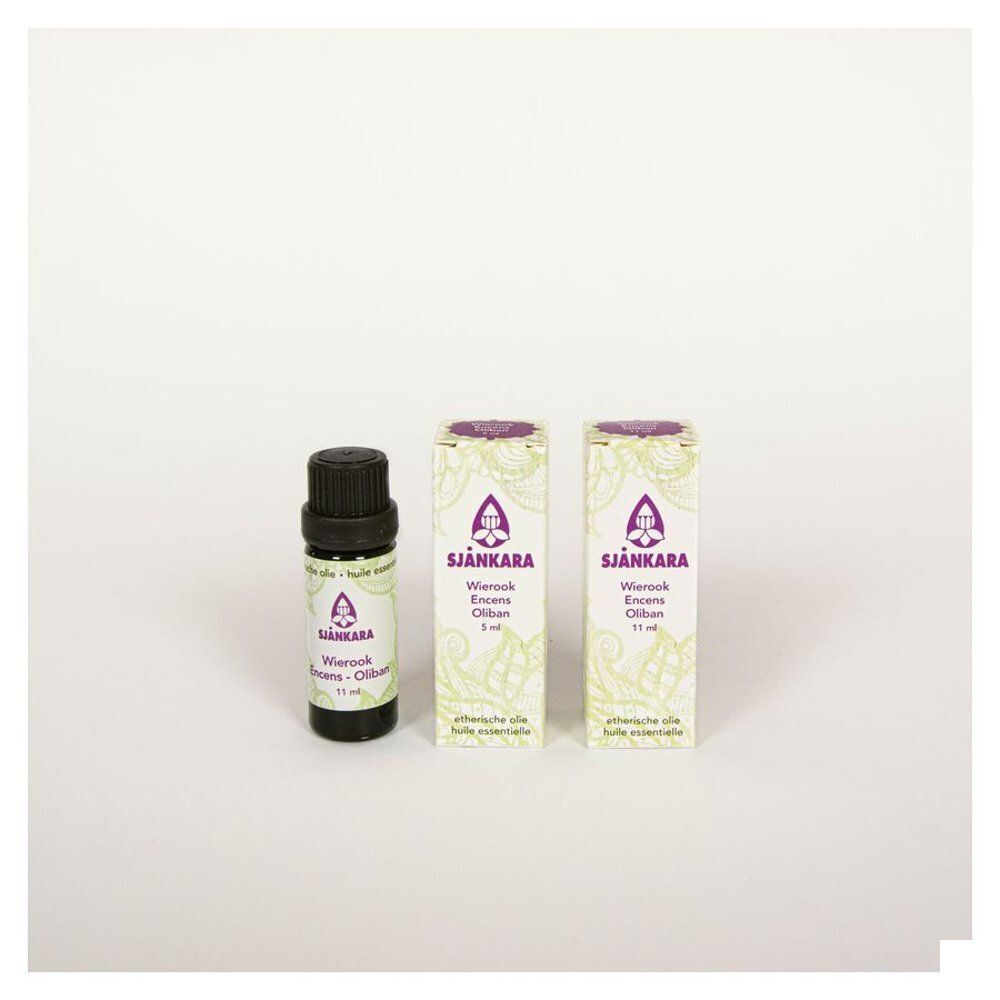 Un flacon d'huile d'encens et deux boîtes à côté. Produit et emballage.