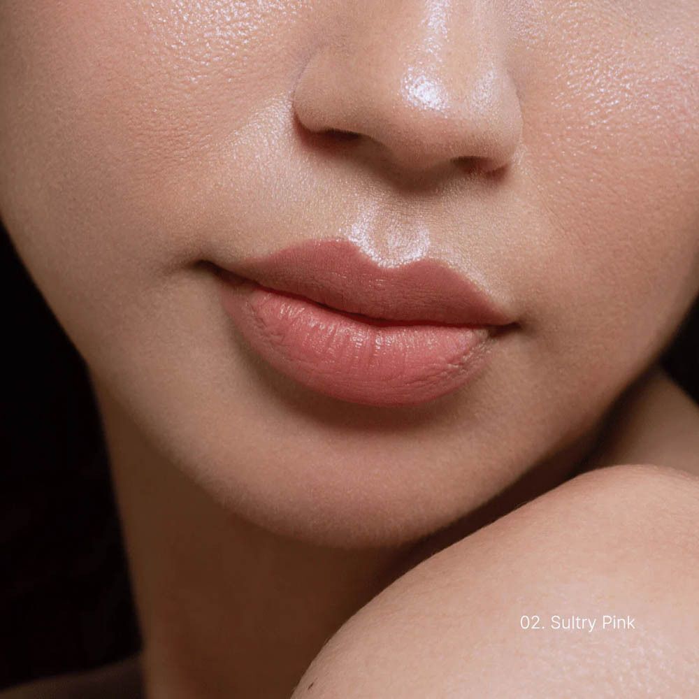 Close-up van een mond met aangebrachte roze lippenstift. Tekst: 02 Sultry Pink.
