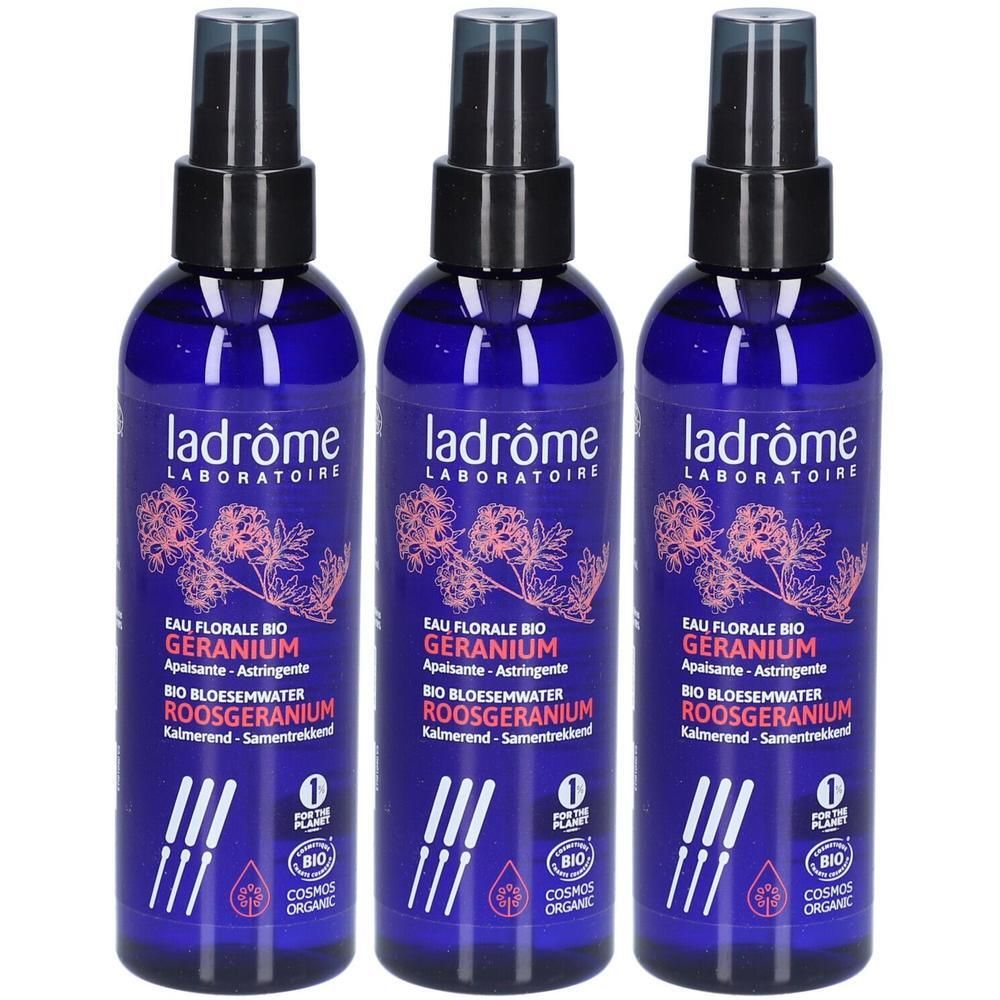 Trois flacons d'eau florale bio Ladrôme à la rose-géranium, avec vaporisateur. Flacons en verre bleu avec étiquette et illustration de plante.