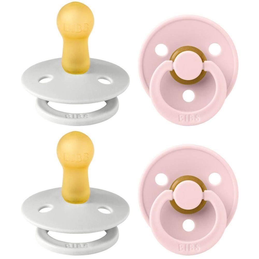 Deux sucettes BIBS : une grise à tétine jaune, une rose à anneau marron. Bouclier rond avec trous d'aération.