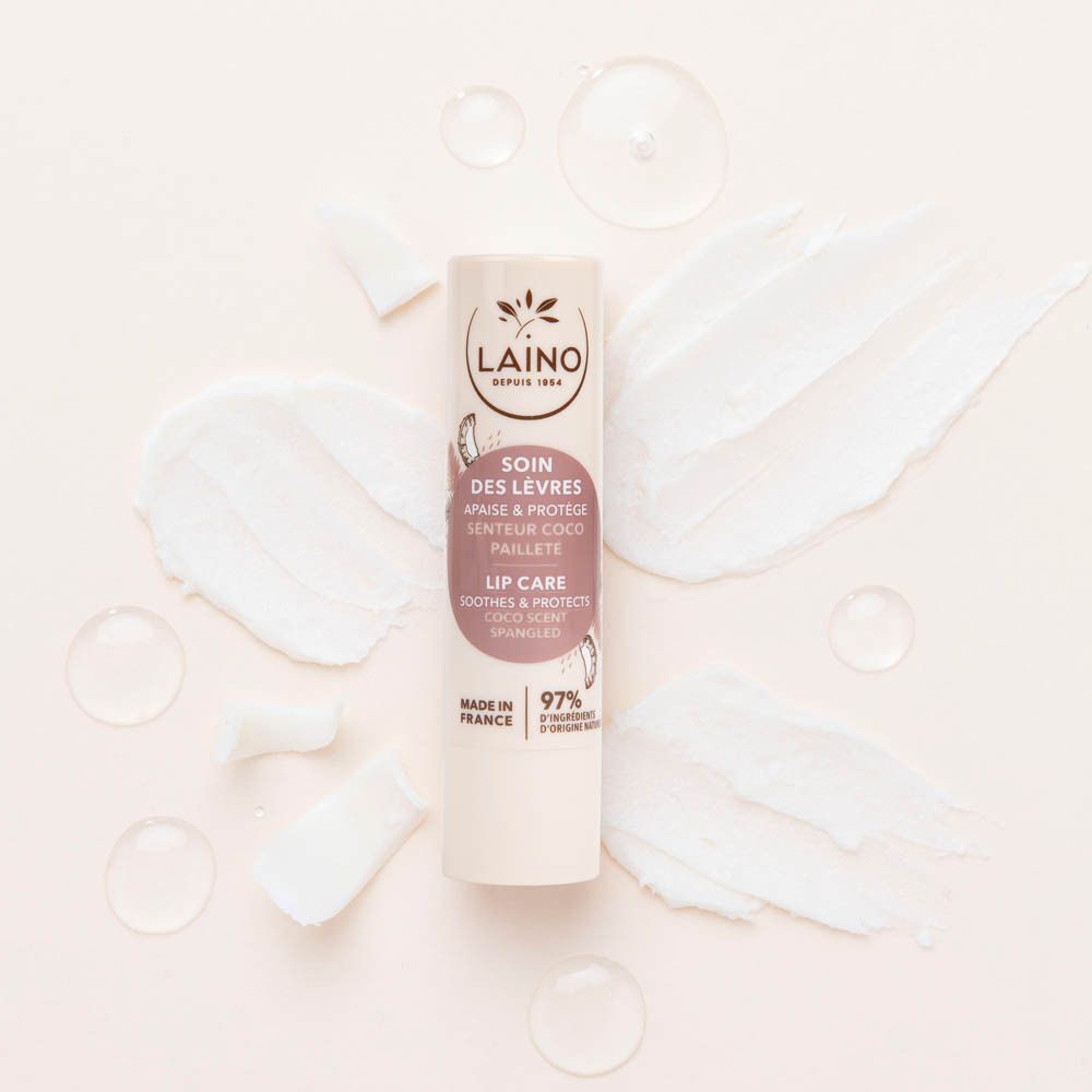 Een Laino lippenbalsemstick, kokosgeur, omringd door kokos- en olie-elementen.
