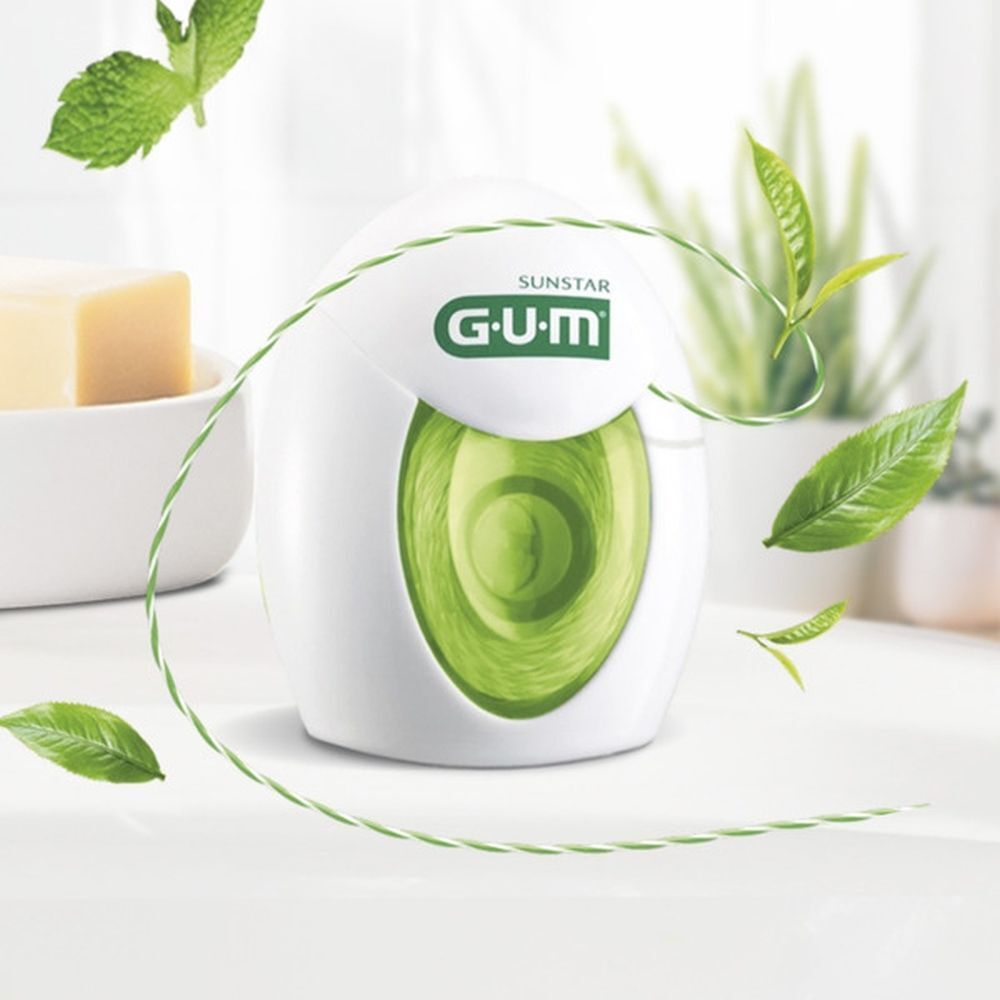 GUM Twisted Floss tandzijde dispenser met bladeren en draad.