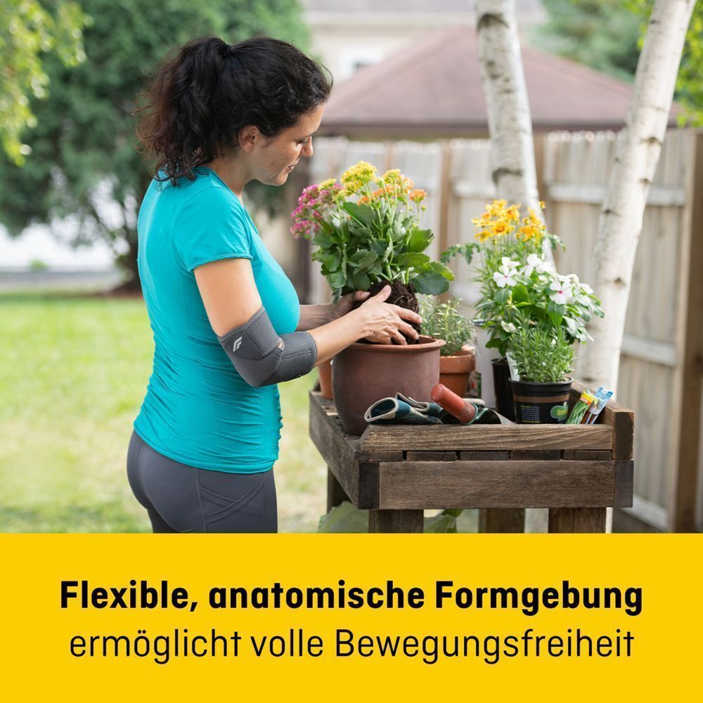 Femme portant un bandage de coude FUTURO Comfort Fit en train de rempoter des plantes dans le jardin.
