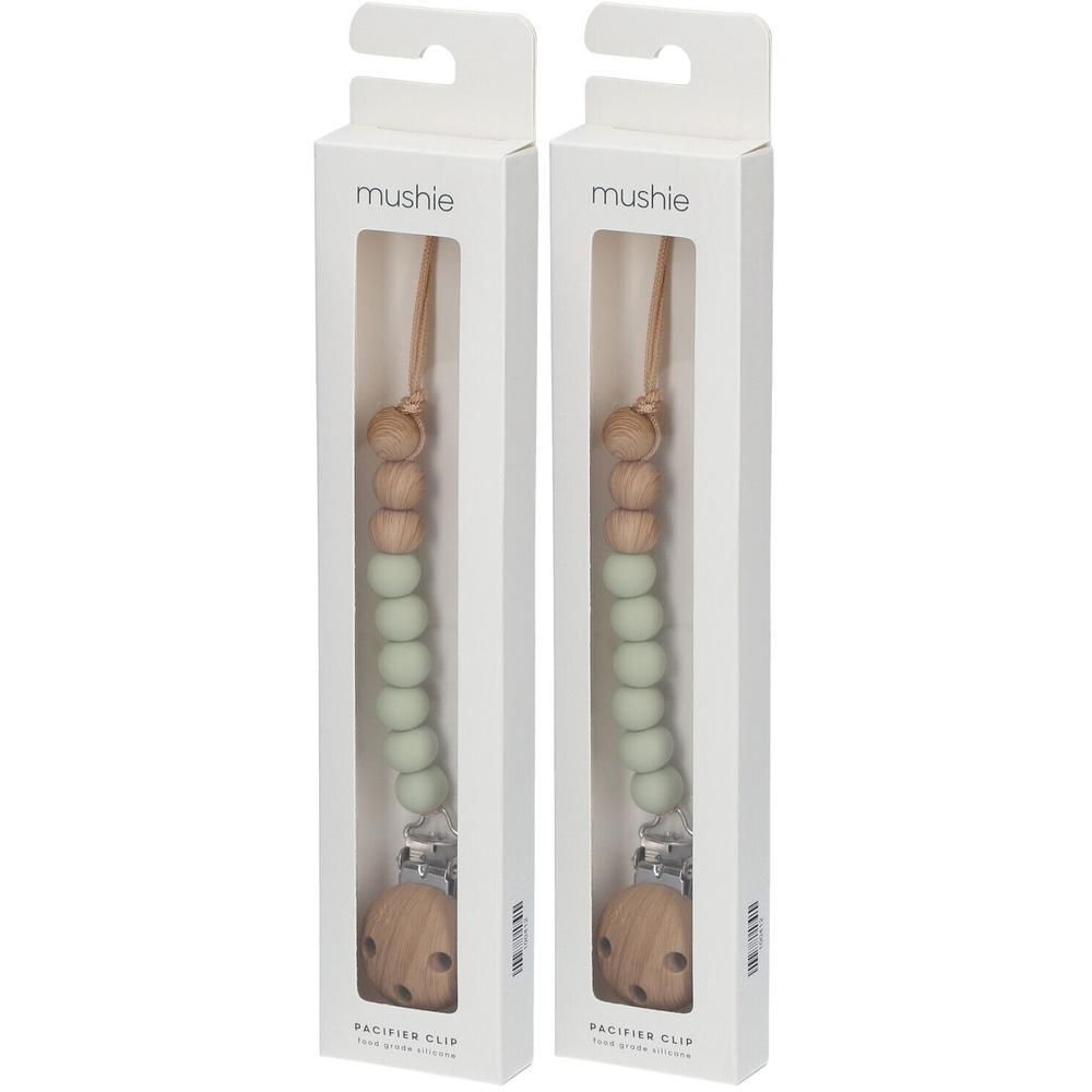 Deux attaches-sucette Mushie vert sauge et bois, emballées.