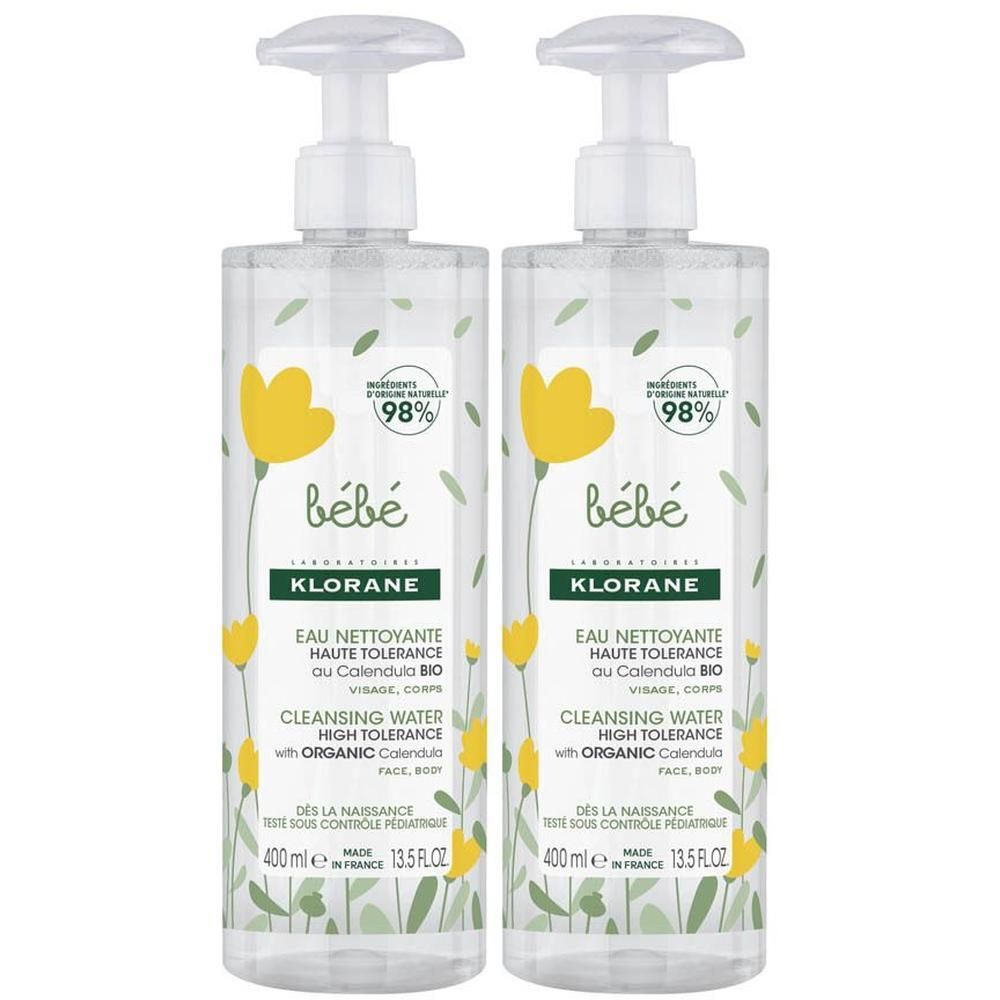 Deux flacons de Klorane Baby BIO Eau Nettoyante avec pompes. Liquide clair avec des fleurs jaunes et des feuilles vertes sur l'étiquette.