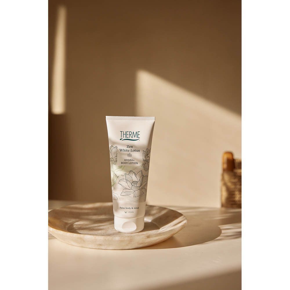 Een tube Therme Zen White Lotus Body Lotion op een schaaltje.