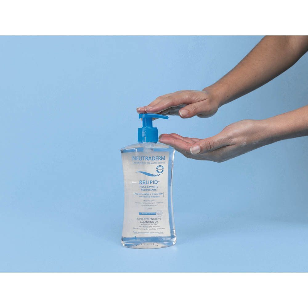 Mains appuyant sur le distributeur à pompe d'un flacon de Neutraderm Relipid+ Huile Lavante Relipidante.