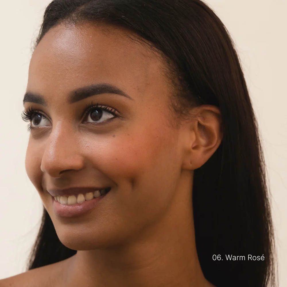 Portret van een vrouw met COULEURS DE NOIR Fusion Glow Foundation, tint 06 Warm Rosé.