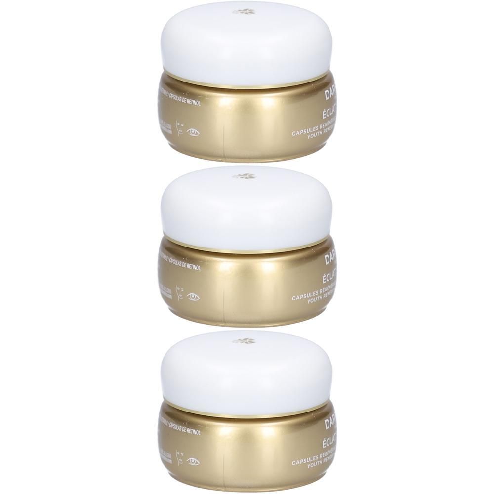 Drie gouden potjes met witte deksels, gestapeld.