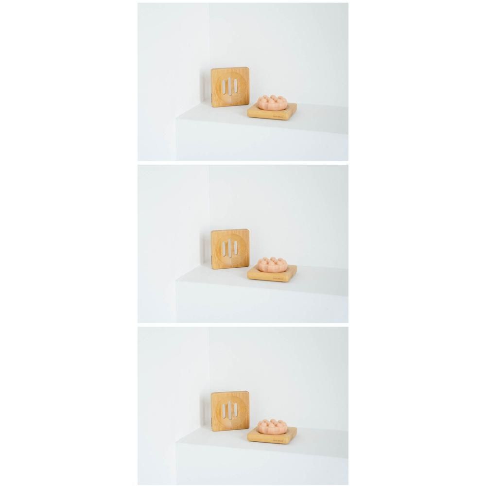 Porte-savon carré en bambou avec un savon rond.