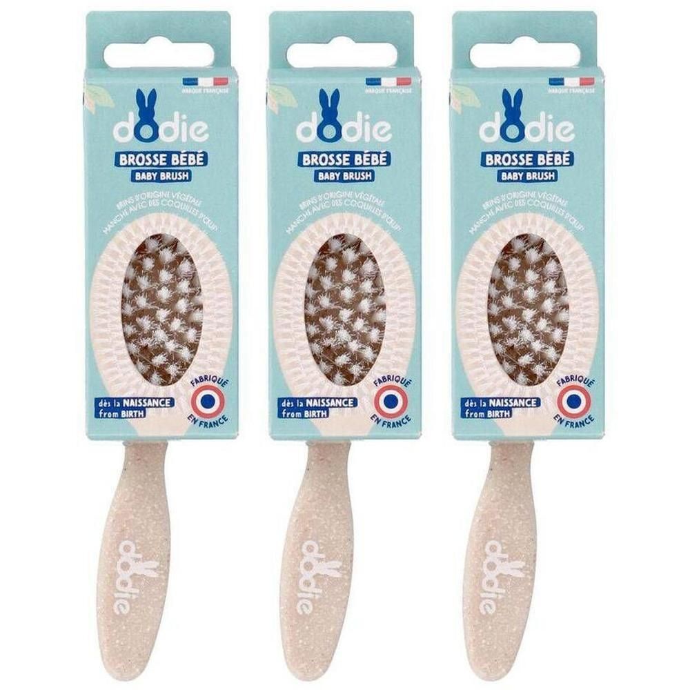 Trois brosses bébé Dodie avec manche beige clair et tête ovale aux poils marron.