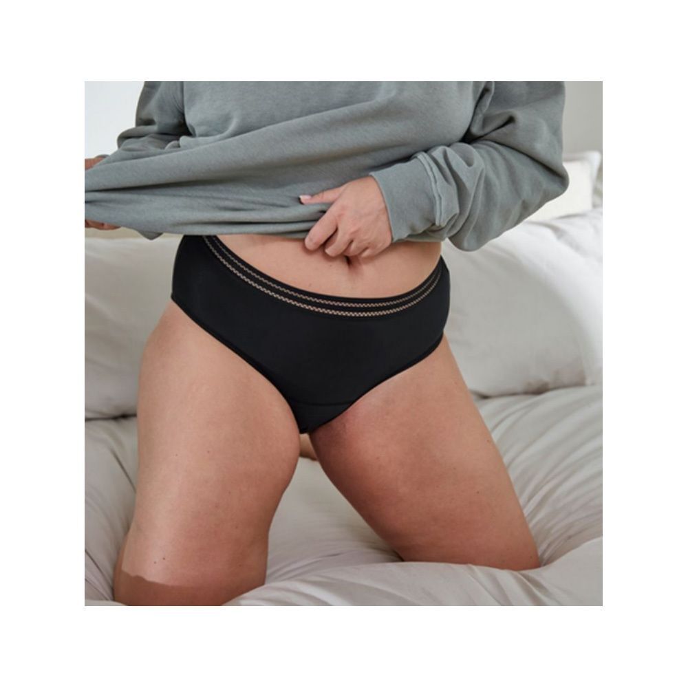 Een zwart Saforelle menstruatieslipje, maat 34-36, zittend op een bed.