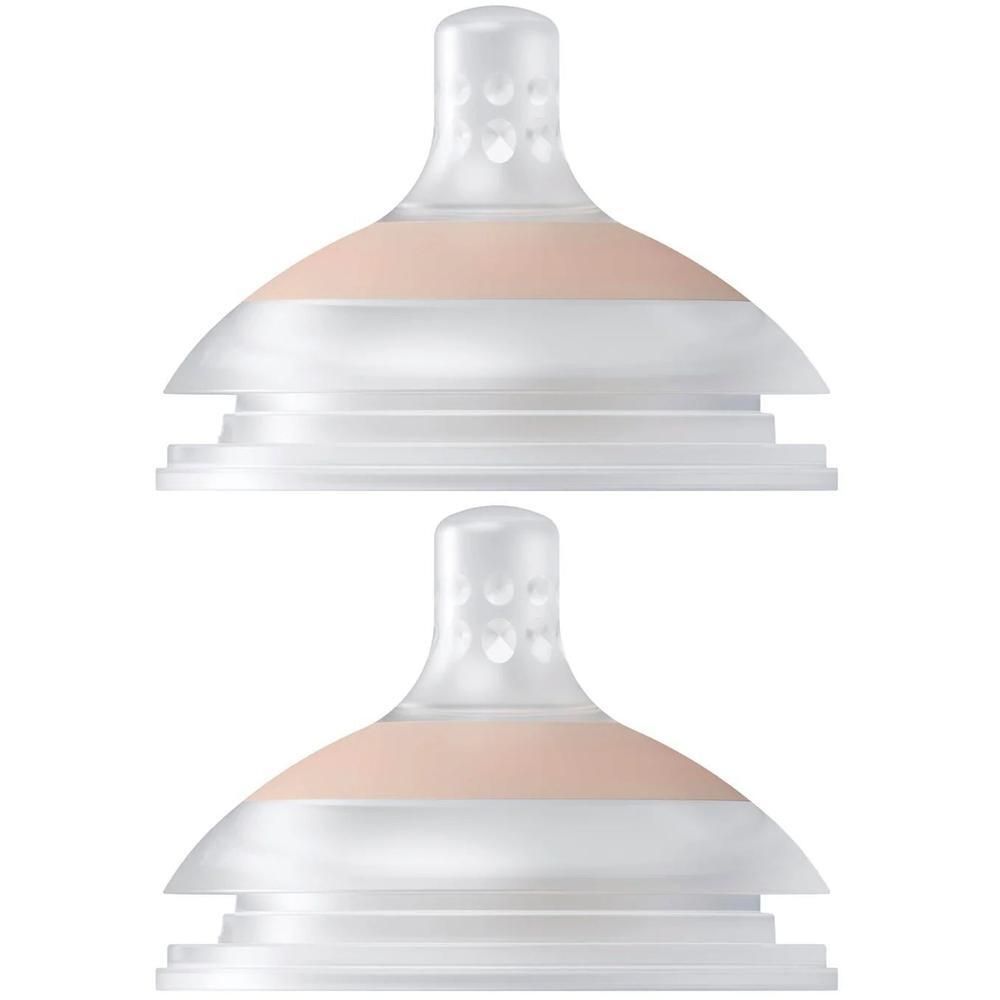 Deux tétines de biberon transparentes avec bande rose et motif à picots.