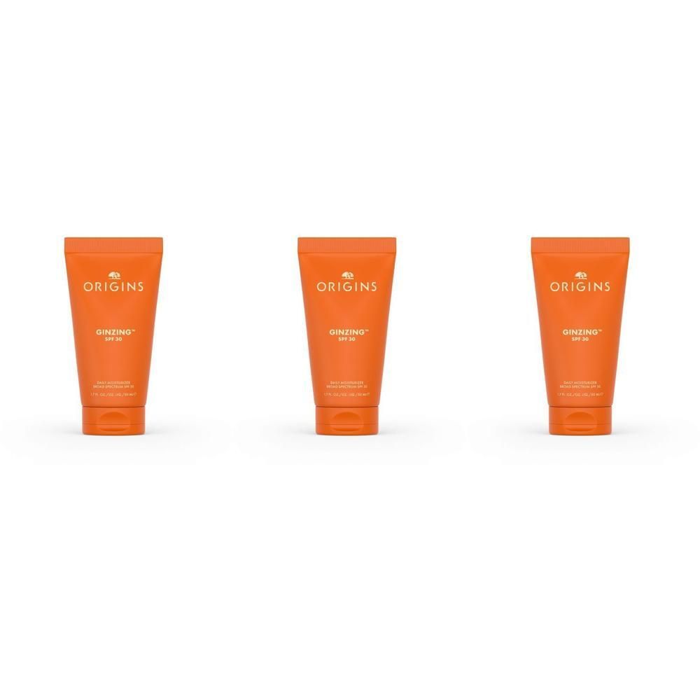 Drie oranje tubes met Origins GinZing Hydratant SPF 30.