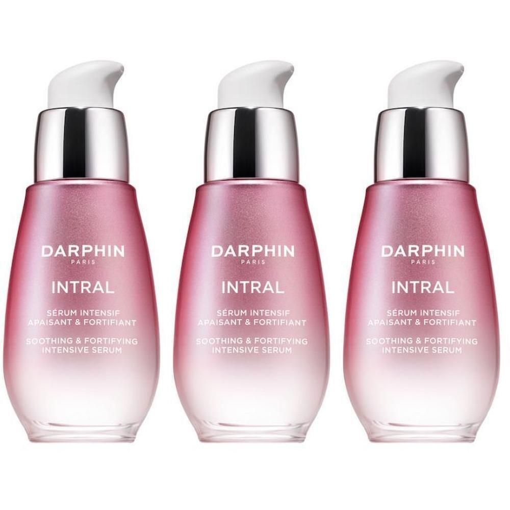 Trois flacons Darphin Intral avec pompes. Flacons en verre rose et transparent avec des accents argentés.