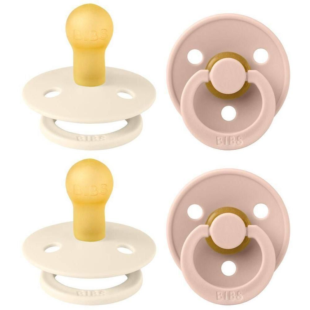 Deux tuttes BIBS : une couleur ivoire avec tétine jaune, une couleur blush avec anneau brun.
