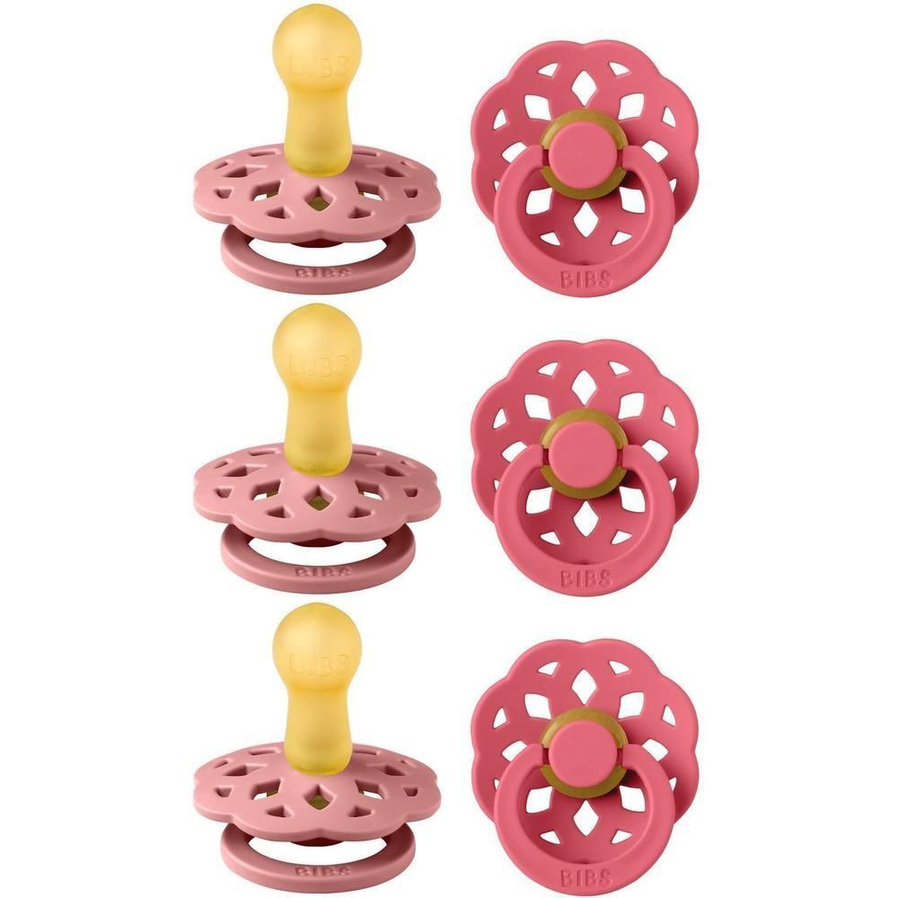 Trois sucettes BIBS roses avec tétine jaune et bouclier ajouré.