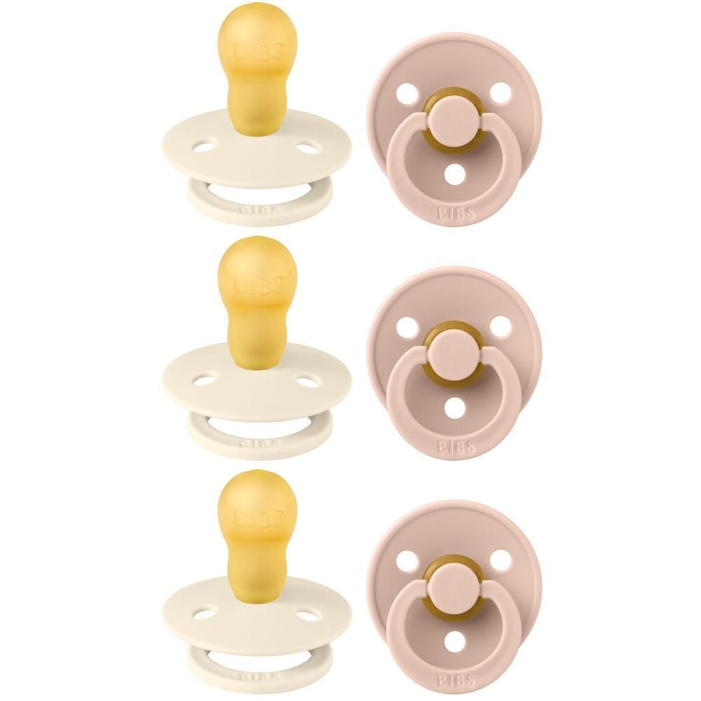 Trois sucettes crème et trois sucettes rose pâle avec tétines jaunes et boucliers crème.