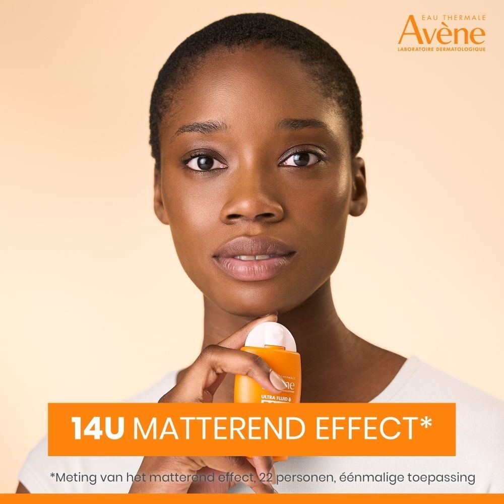 Vrouw houdt Avène Ultra Fluid zonnebrandfles vast. Tekst: 14H matterend effect.